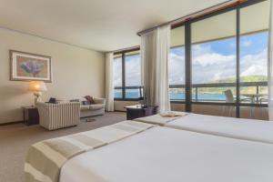 a hotel room with two beds and a large window at Pestana Bahia Praia Nature & Beach Resort in Vila Franca do Campo