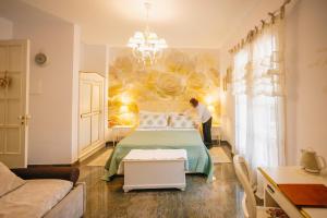 a person is painting a wall in a bedroom at B&B Blanc Maison Etna Relais & Charme in Nicolosi +73 photos