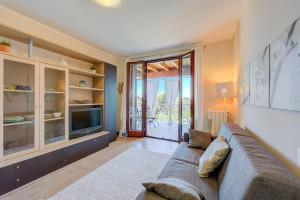 sala de estar con sofá y TV en Appartamento Zelda With Shared Pool - Happy Rentals en Desenzano del Garda
