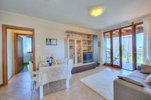 salon ze stołem i kanapą w obiekcie Appartamento Zelda With Shared Pool - Happy Rentals w mieście Desenzano del Garda