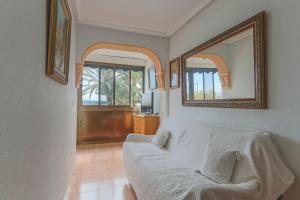 een woonkamer met een witte bank en 2 spiegels bij 015 - Thailandia I 001 - comfortHOLIDAYS in Santa Pola