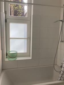 3 Zimmer-Lounge in KÖLN Sülz mit Küche, Balkon, 2 Bäder في كولونيا: حمام مع نافذة وحوض استحمام ومغسلة