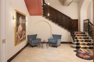 una hall con due sedie e una scala di Anglo American Hotel Florence, Curio Collection By Hilton a Firenze