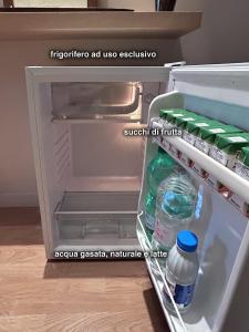 - un réfrigérateur ouvert avec des bouteilles d'eau dans la porte dans l'établissement B&B La Littorina Parcheggio Umbria Centro Ideale Rasiglia Cascate di Pale Ponte Tibetano Sellano, à Foligno