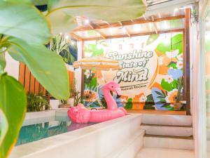 a pink inflatable pink flamingo sitting on steps next to a pool at Roemah Renjana Sunny in Pampang