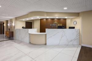 a lobby of a wingate hotel with a marble counter at Wingate by Wyndham Troy in Troy