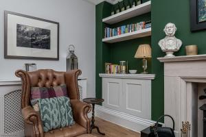 a living room with a chair and a fireplace at No22, Llandudno - Stylish & Cosy Period Apartment, with Hot Tub & Private Parking in Llandudno