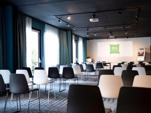 een lege ruimte met stoelen en een presentatie bij ibis Styles Strasbourg Nord Palais des Congrès in Schiltigheim