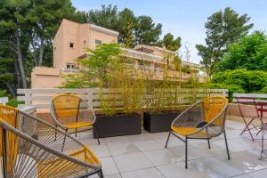 - un ensemble de chaises assises sur une terrasse dans l'établissement Appartement Angelin - Welkeys, à Aix-en-Provence
