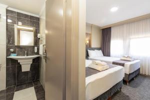 a hotel room with two beds and a sink at BURSA LOYAL CiTY HOTEL & SPA in Bursa