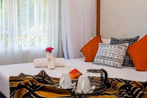 ein Hotelzimmer mit einem Bett und einem Tablett mit Essen darauf in der Unterkunft SWAHILI BEACH APARTMENTS in Mombasa