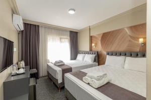 a hotel room with two beds and a television at BURSA LOYAL CiTY HOTEL & SPA in Bursa