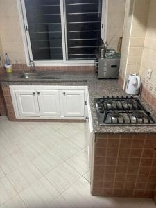 a kitchen with a stove and a sink at Appartement in Casablanca