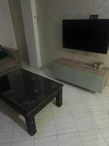 a living room with a coffee table and a flat screen tv at Appartement in Casablanca