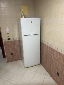 a white refrigerator in a corner of a room at Appartement in Casablanca