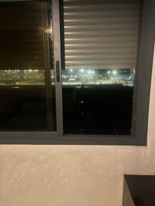 a window with a view of a city at night at Appartement in Casablanca