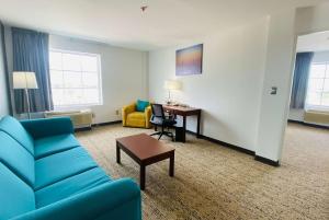 a living room with a blue couch and a desk at La Quinta by Wyndham Reynosa in Reynosa