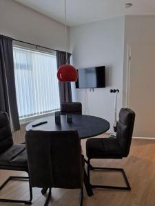 sala de estar con mesa, sillas y lámpara roja en MainStreet20, en Stykkishólmur