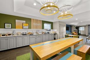 a large kitchen with a wooden table in it at Spark By Hilton Tifton in Tifton