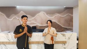 un hombre y una mujer parados frente a una cama en Remember Vangvieng Hotel, en Vang Vieng