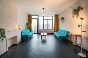 a waiting room with blue chairs and a fireplace at Charming and Spacious Apartments in the Heart of Antwerp in Antwerp