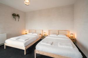 dwa łóżka siedzące obok siebie w pokoju w obiekcie Charming and Spacious Apartments in the Heart of Antwerp w Antwerpii