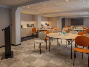 une salle de conférence avec des tables, des chaises et un écran dans l'établissement Mercure London Earls Court, à Londres