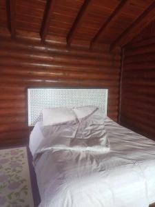 a bed with white sheets and pillows in a room at Chalet's lake_Bolu Abant _log house in Piroğlu
