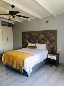 um quarto com uma cama grande e uma ventoinha de tecto em Elihle Guest house em Empangeni