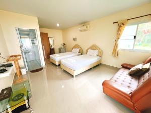 uma sala de estar com duas camas e um sofá em พายเนอรี รีสอร์ท @แหล่มแท่น (Pinery Resort) 