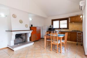 cocina con mesa y chimenea en Mirto 4 Apartment, en Santa Maria Navarrese 5 fotos más