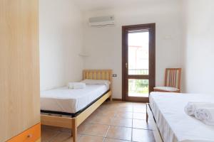 2 camas en una habitación con ventana en Apartment Mirto 4, en Santa Maria Navarrese