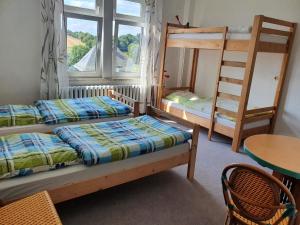 a bedroom with two bunk beds and a table at Monteurzimmer Alte Schule Heberndorf 1 in Wurzbach