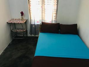 a bedroom with a blue bed and a table at FS Hotel & villa in Arugam Bay