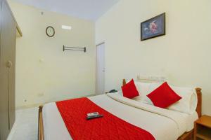 sypialnia z dużym łóżkiem z czerwonymi poduszkami w obiekcie Infosys Thoraipakkam Near Ecr Beach w mieście Ćennaj