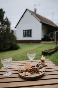 a plate of sandwiches and wine glasses on a table at Ildikó Vendégház in Magyarszombatfa