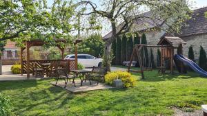 un patio trasero con una mesa de picnic y un parque infantil en Bakonyi Kiscsillag, en Bakonybél