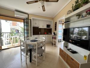 cocina y comedor con mesa y TV en El retiro Denia, en Denia