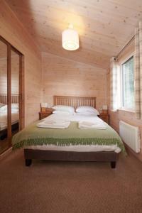 a bedroom with a bed in a wooden room at Burgie Woodland Lodges in Forres