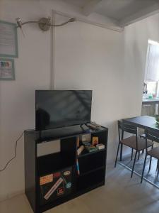 uma televisão de ecrã plano em cima de um centro de entretenimento preto em Maison 61 em Catânia