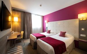 duas camas num quarto de hotel com paredes roxas em Kyriad Prestige Saint-Malo em Saint Malo