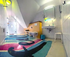 uma casa de banho com um piso colorido e um lavatório. em feels Beach Club Hotel em Kühlungsborn