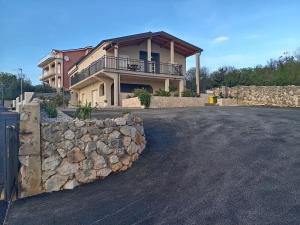 a house with a stone fence and a stone wall at Apartmani Suzana in Crikvenica