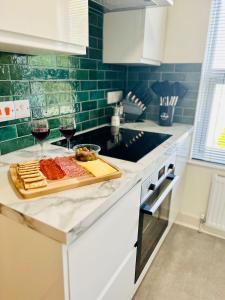 a kitchen counter with two glasses of wine and food at Kensington Park in Reading