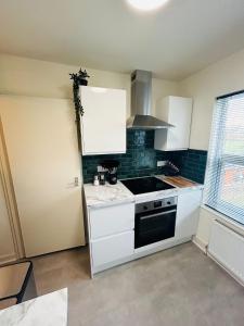 a kitchen with white cabinets and a stove top oven at Kensington Park in Reading