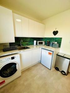 a kitchen with white cabinets and a dishwasher at Kensington Park in Reading
