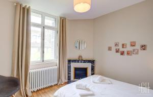 a white bedroom with a bed and a fireplace at Casa Simone / Bords De Loire in Tours