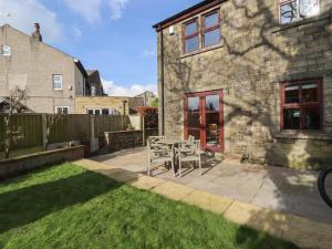 a patio with a table and chairs in a yard at 5 Emmott Court in Colne