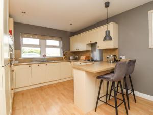 a kitchen with white cabinets and a counter top at 5 Emmott Court in Colne