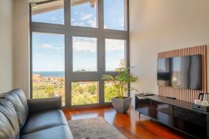 un salon avec une télévision et une grande fenêtre dans l'établissement Lafitenia Resort, à Saint-Jean-de-Luz